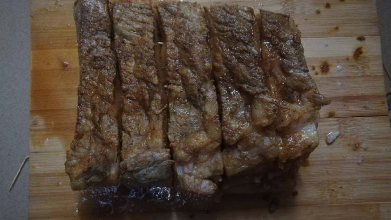 脆皮烧肉,接着用竹签串好,如果没有长竹签,用牙签也是可以代替的,这样可以避免烤的时候肉卷起来