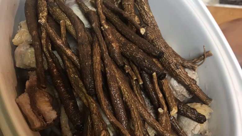 女性元气汤:野生甜当归炖土鸡,在鸡上铺上洗好的野生甜当归。