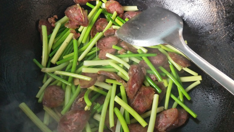 年菜 蒜薹炒腊肠,翻炒,将蒜薹炒熟。
