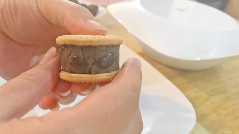 珍藏版红豆夹心饼
,旋转饼干，用另外一只手捏圆红豆馅。