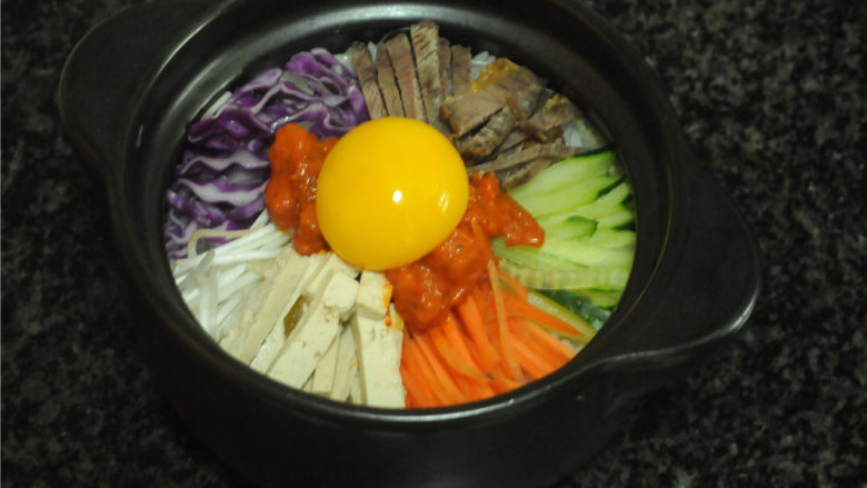 韩式砂锅拌饭,鸡蛋磕出来,将蛋黄摆在泡菜中间