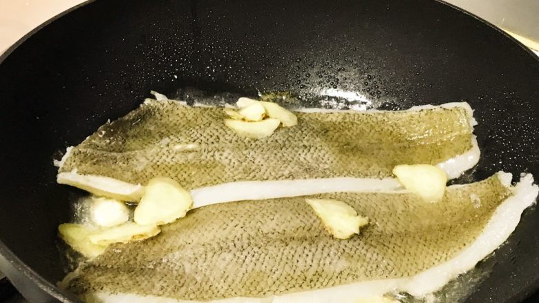 烧比目鱼柳,加入姜片,煎一下。