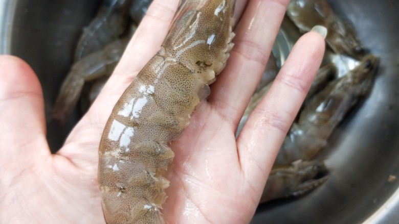 节节高升美味油焖大虾,用牙签从虾背第二节处挑去虾线,再剪去虾脚。
