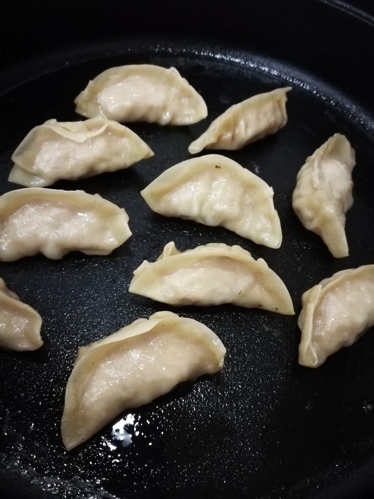 韭黄虾仁煎饺,大约几分钟后水收干,煎饺也差不多好了。