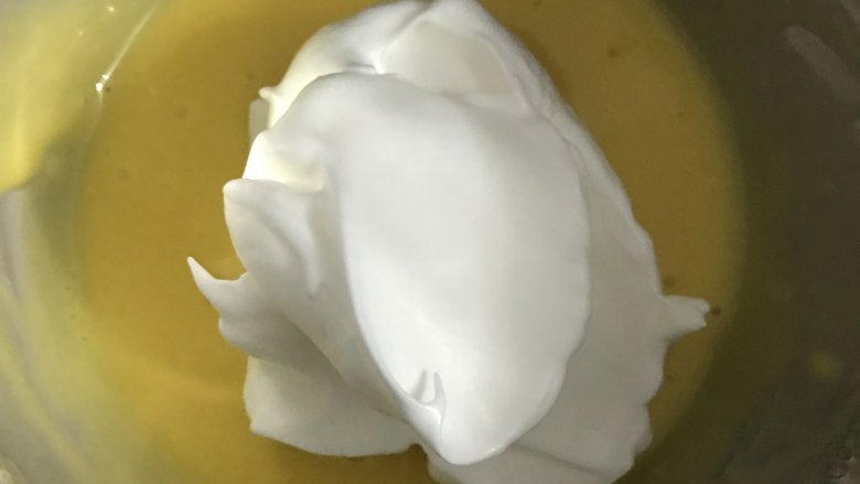 爱心草莓蛋糕卷,取三分之一蛋白放入蛋黄液中,用翻拌与切拌手法将两者混合均匀