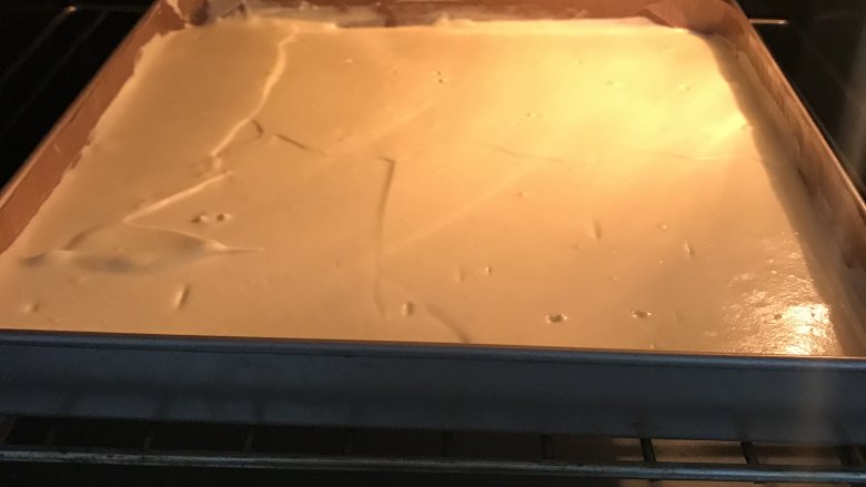 爱心草莓蛋糕卷,放入预热好150度烤箱中,烤20分钟。出炉后从高处摔一下,垫张油纸倒扣在烤网上,撕掉油布,再翻转过来盖上油纸晾凉。