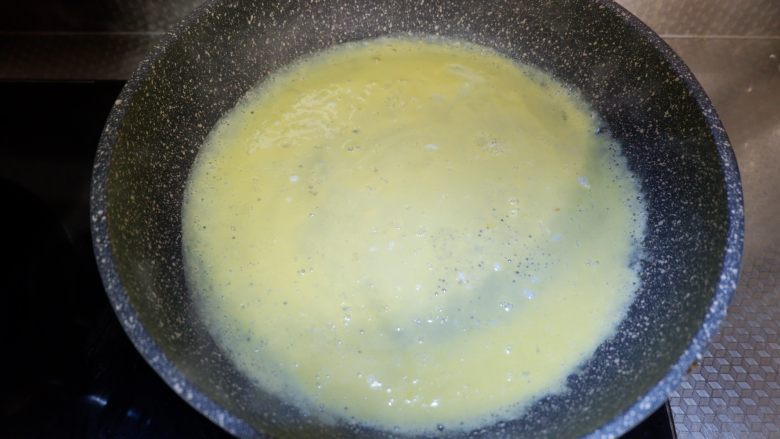 小白菜炖蛋饼,锅中抹少许油，将蛋液倒入锅中摊平。