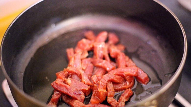 黑椒牛肉炒意粉,锅中下色拉油,倒入牛肉炒至变色。