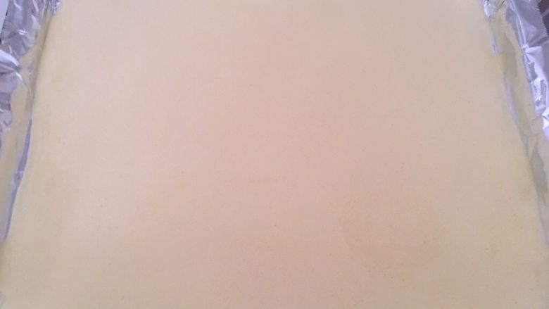 虎皮蛋糕卷,烤盘铺油纸,我用的30L烤箱自带的烤盘,将打发好的蛋黄糊倒在模具内,用刮棒刮平正