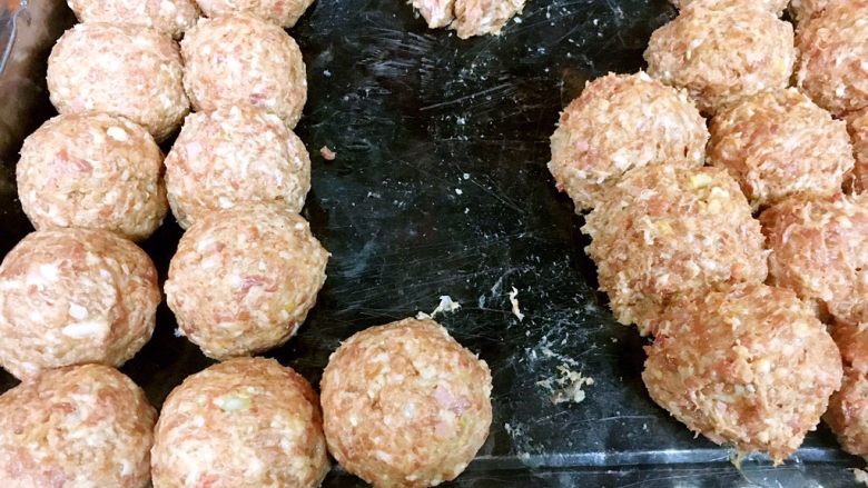 做年货 团团圆圆年夜饭 四喜丸子,我们再给丸子做第二次整形,一是调整一下大小,让丸子的大小更整齐,二是再用力团团且挤压一下丸子,将里边的气体排出,这样丸子更漂亮更牢固。 图中左边是第二次整形后的丸子,看上去比右边初步整形的丸子圆润的多了,是不是更漂亮了。