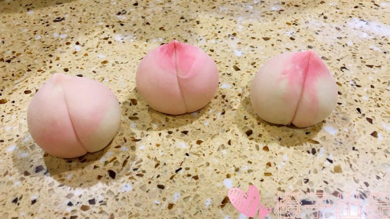 卡通馒头,桃子:
分出4个75克重的白面团按照做草莓的方法、整形成团
取五克粉色面团按平包住白色面团的顶部
慢慢滚圆 把面团的顶部拉长一些 模仿桃子的形状,最后用面板在中间压出一条线 做出桃子的样子即可~~