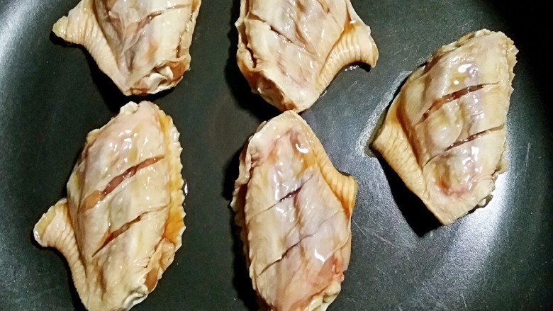 柠香鸡翅(无油版),不沾平底锅预热后将鸡翅外侧(没有打花刀的那面)先煎一下,鸡翅煎的时候自己会出油,所以锅中不用放油了。