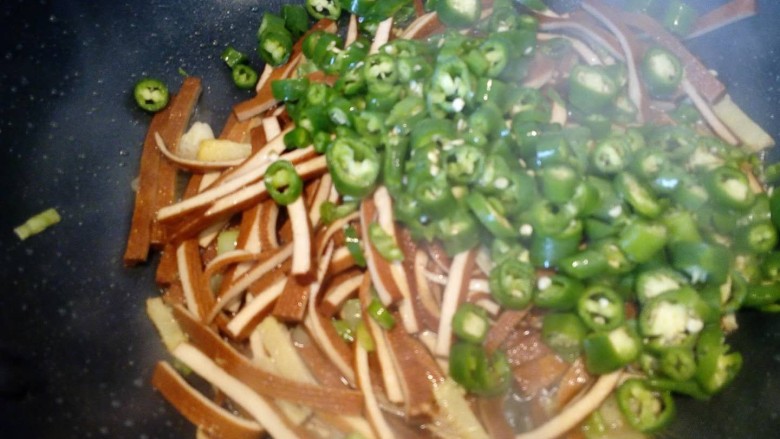 年夜饭~辣爽杭椒香干,加入切好的杭椒粒,大火爆炒。