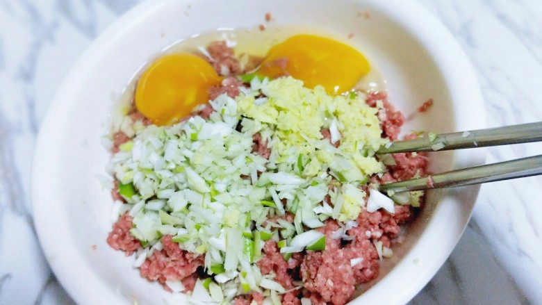 年夜饭&守岁的牛肉馅饺子,牛肉糜中加入鸡蛋,切碎的葱姜,拌均匀,静止5分钟。
