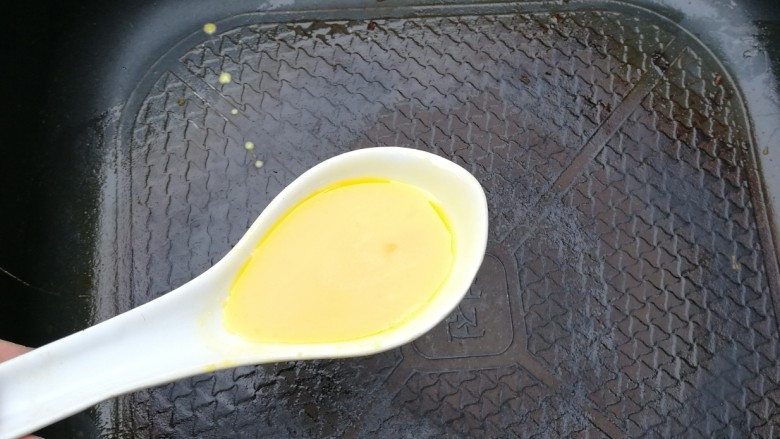 年味+金光灿灿元宝蛋饺,中小火烧热锅,用肥肉擦一擦锅底,用调羹舀一勺蛋液倒入锅中