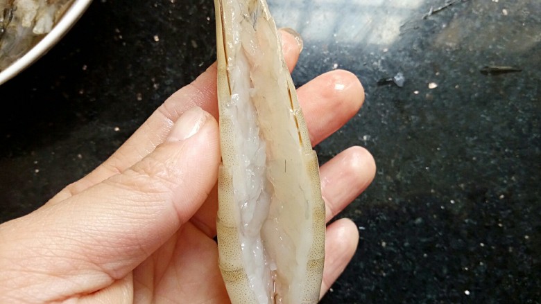 蒸蒸日上~蒜香扑鼻的蒜蓉粉丝蒸大虾,接下来第二步:虾拿在手上,虾背朝上,从虾的头部下面开始剪开到虾尾处,尾巴去掉。