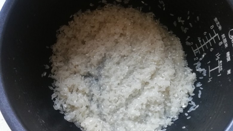 年味~腊肠青菜饭,米清水洗净,倒入电饭煲中待用。