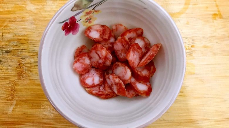 本地菜心蒜香木耳炒腊肠,<a style='color:red;display:inline-block;' href='/shicai/ 4536'>腊肠</a>稍微冲洗一下,如图所示,斜45°切成薄片,控干水分,备用