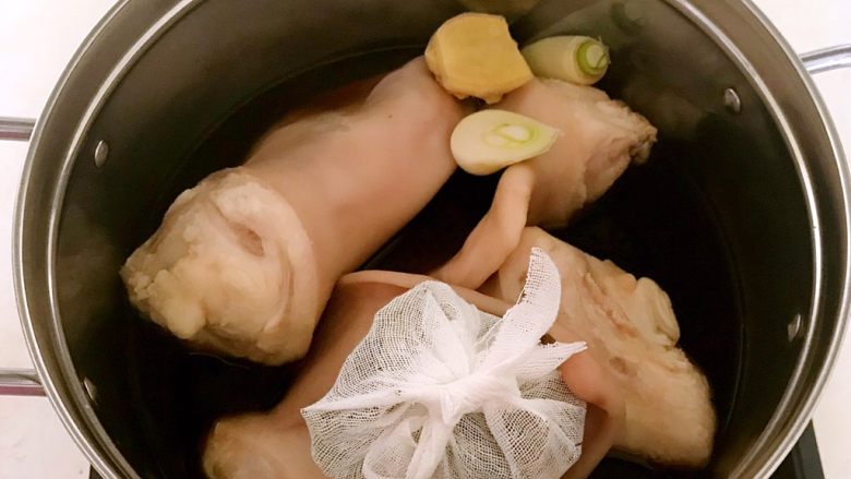 红油猪耳,加入干料包,加入葱段和姜片