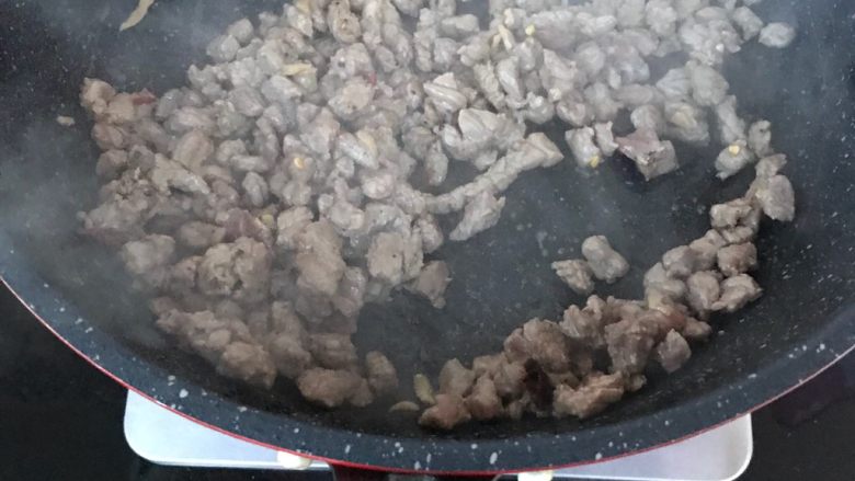 小炒黄牛肉,油温升高把牛肉丁倒入锅中爆炒