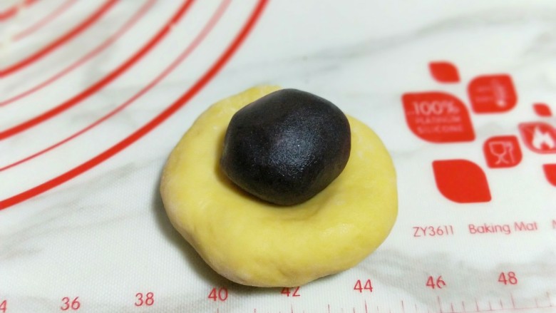 香甜松软的南瓜小面包,取一块面团,用掌心压扁,当上豆沙馅。