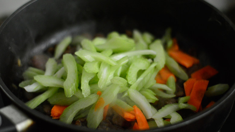 西芹炒牛肉,放入西芹和胡萝卜炒制