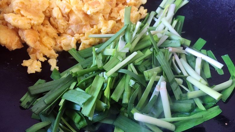 春节初二回娘家三鲜卤面四拌菜之一 摊黄菜,把炒好的鸡蛋盛出备用,或者把炒好的鸡蛋扒在锅的一边,用炒鸡蛋剩下的油炒韭菜,翻炒2或者3下就可以,把韭菜的香味炒出来就好了。