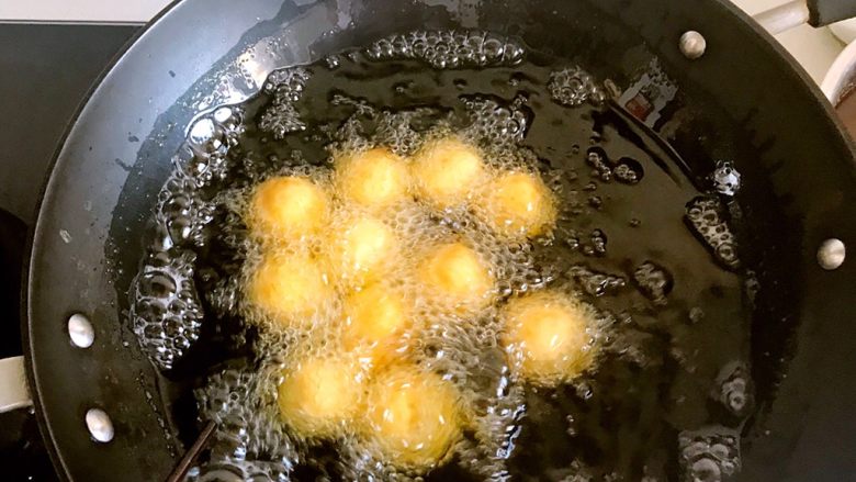 香炸红薯丸子,锅中添油,油七八分热的时候就可以下锅了,,太热的油会使红薯丸子表面糊了,里面还没有熟,所以要中小火慢炸。