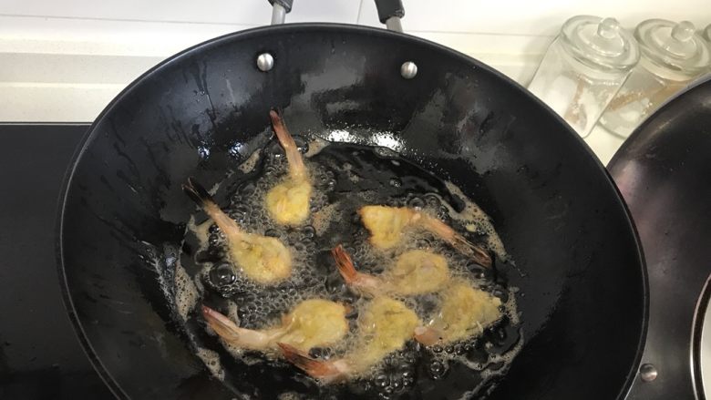 香酥黄金虾,把虾放进油中炸,不断的用筷子翻个儿,以免炸糊了。