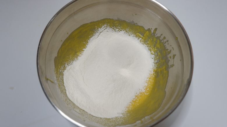 百香果小蛋糕,筛入<a style='color:red;display:inline-block;' href='/shicai/ 548'>低筋面粉</a>，用刮刀画J字形翻拌均匀。