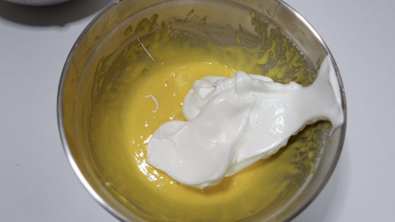 百香果小蛋糕,分三次将蛋白加入蛋糕糊中，先取1/3蛋白加入蛋糕糊中，搅拌至完全融合