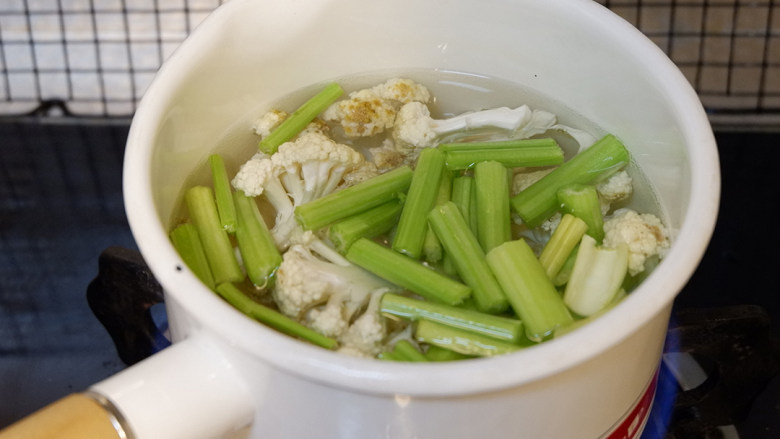 肥牛麻辣香锅,锅中烧开水,加入西芹和菜花焯水。焯好沥干水备用。