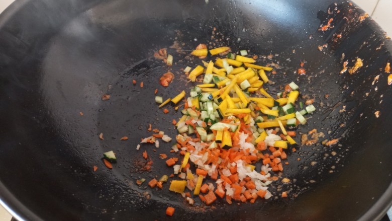 虾仁时蔬焗饭,放入黄瓜胡萝卜,南瓜洋葱碎翻炒至半熟