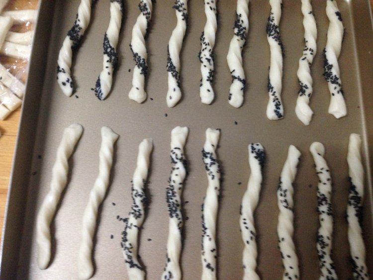 低脂小点――奶香面包棒,摆入烤盘,将面包棒上喷少许水,加盖保鲜膜。饧发30分钟