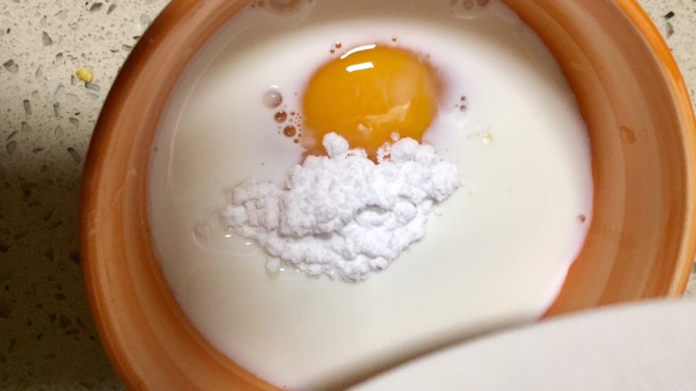 创意果丹皮黄油蛋挞,继续放入糖粉,把碗里的食材调匀,多调拌一会
