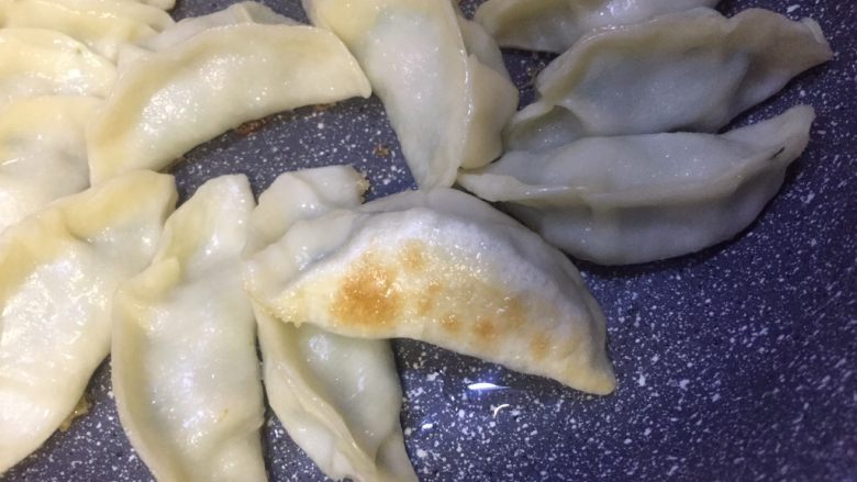 #春节健康菜#和和美美大团圆,饺子在煎制过程中需要晃动锅两三次,以达到受热均匀的效果,水干后饺子皮变微透明底部已有焦黄色