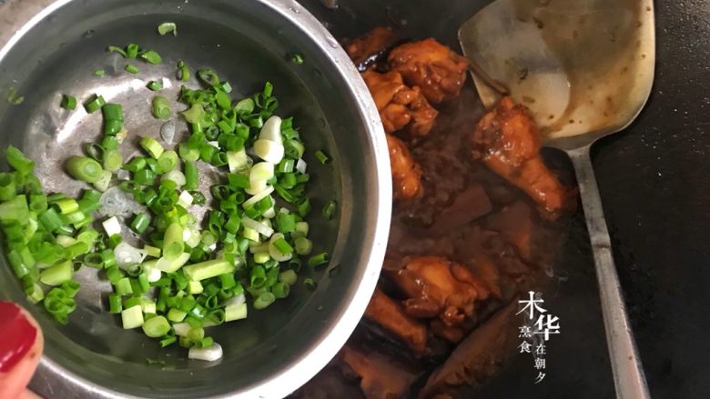 香菇焖鸡翅根,焖至汁水快干时调大火翻炒收汁,然后加入葱花。