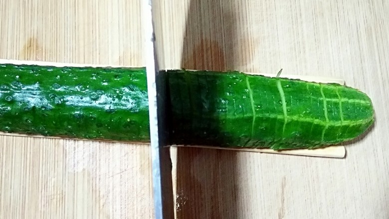 蓑衣黄瓜,黄瓜一面切完45度斜刀后翻转另另一面,切90度直刀,还是不要切断,两面切片都要均匀。