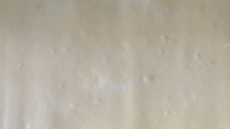 古早味肉松蛋糕卷,烤盘垫油布,倒入混合好的蛋糕糊,震掉大气泡,静置几分钟。