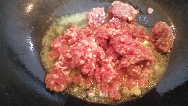 蒜苔牛肉打卤面,锅里添油烧热,放入牛肉馅儿。
