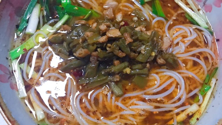 酸豆角肉丁米线,将辣椒油拌匀之后,放入酸豆角肉丁,撒上白芝麻就OK了。