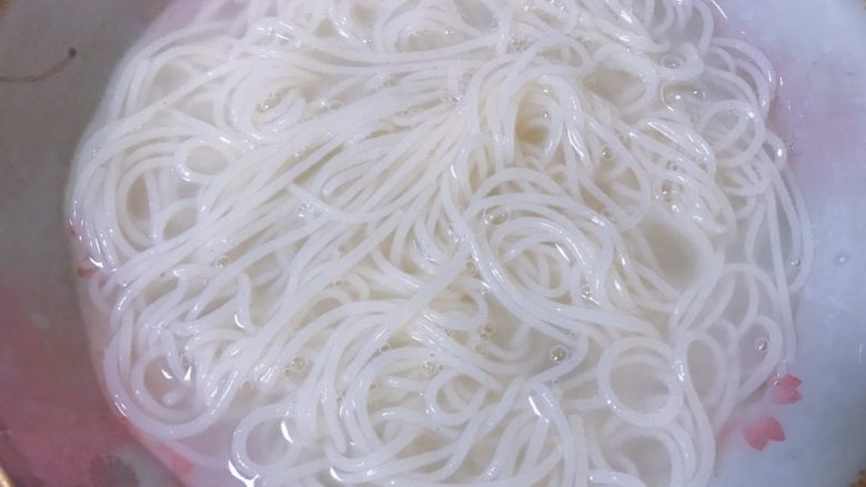 酸豆角肉丁米线,提前准备一盆冰的矿泉水,煮好的米线捞出后直接放入冰水中;