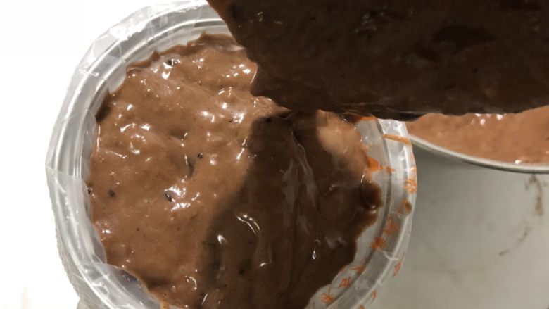 巧克力香蕉麦芬蛋糕 ukoeo风炉制作,液体和干粉混合均匀。把巧克力放进去,再搅拌均匀。
用一个勺子或者直接拿着盆把面糊倒在一次性裱花袋子里。这样好往纸杯里倒。
