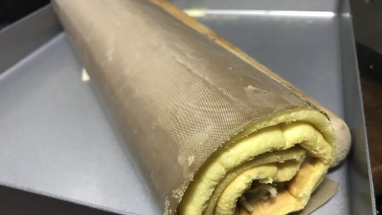 古早味肉松蛋糕卷,卷起来之后放在烤盘里,放冰箱冷藏数小时定型即可。