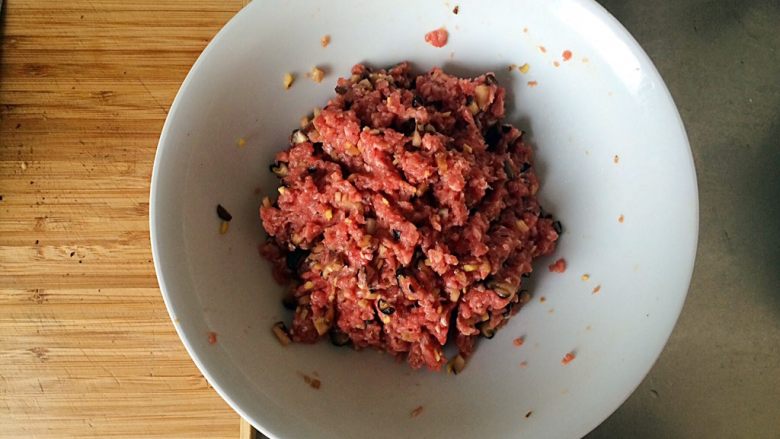 土豆牛肉丸子烩饭,用筷子或手,延一个方向搅拌均匀后静置腌20分钟。