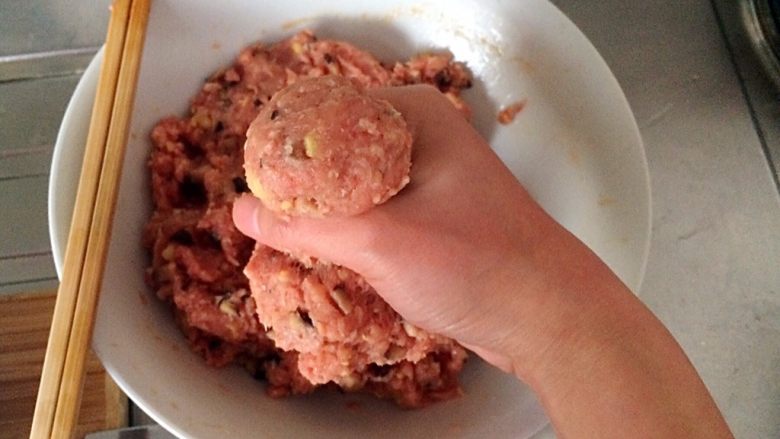 土豆牛肉丸子烩饭,用虎口挤出一个丸子,并揉紧实。