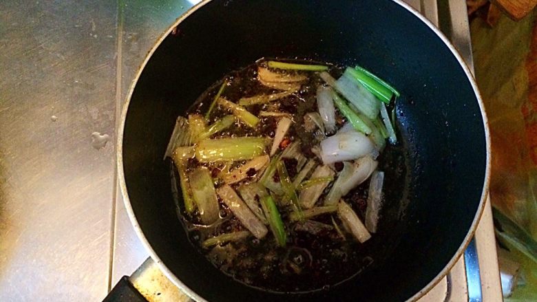 土豆牛肉丸子烩饭,将煎丸子锅里的油倒出一部分,留适量的油,放入切好的大葱。