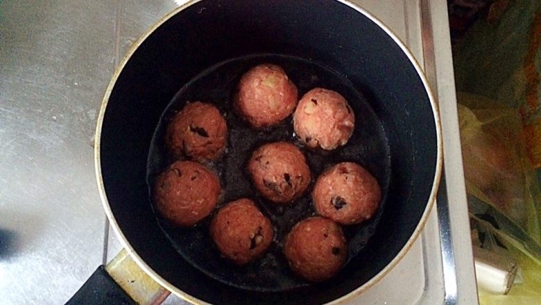 土豆牛肉丸子烩饭,不粘锅中倒适量的油(大概没过丸子的三分之一即可),将丸子放入锅中,开始煎。