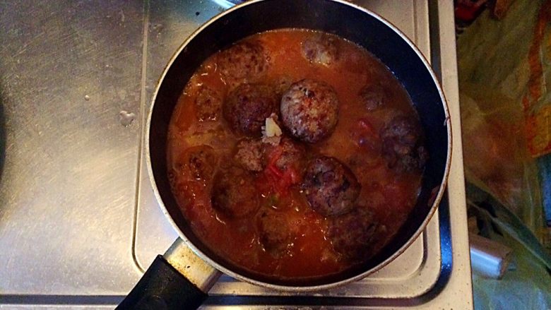 土豆牛肉丸子烩饭,当炒成西红柿酱时,倒入煎好的丸子,并将泡香菇的水倒入锅中,加入少许的盐,盖上锅盖,大火煮约5分钟。