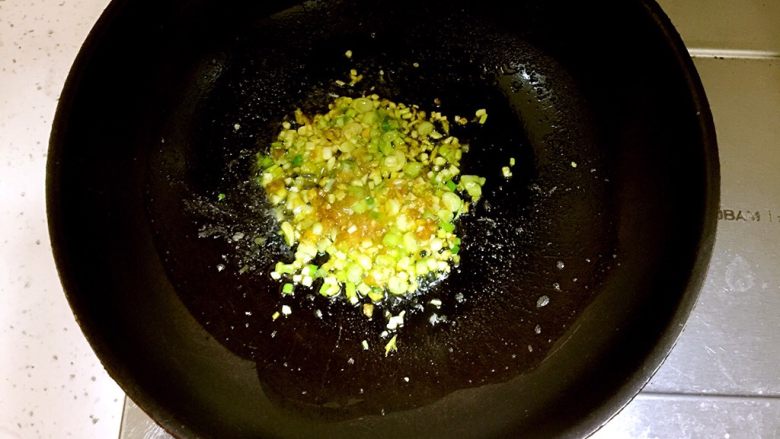 白萝卜肥牛汤,锅中放入约5ml食用油,因为这汤是要喝的,所以食用油不宜过多,待油五成热时放入姜末蒜末葱白和1茶匙黄灯笼辣椒酱炒出香味,切忌黄灯笼辣椒酱不宜多放,因为非常的辣,如果放多了汤就没法喝了,黄灯笼辣椒酱主要用于配合汤和肥牛提味增味。